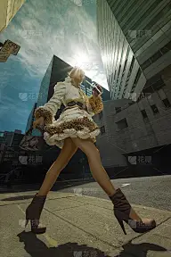 一位身穿咖啡过滤外套，手拿咖啡豆制成的手袋，走在城市建筑前的迷人年轻女子的地面视图