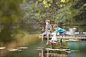 Boys fishing and playing with toy sailboat at lake by Caia Images on 500px