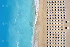 海滩的俯视图与对称的日光浴床和遮阳伞