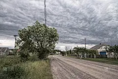 美丽的，史诗般的雷雨云在一个村庄，有一条通往未知的道路。在欧洲，天空是飓风的前兆。库存照片云设计