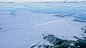女人在贝加尔湖的冰上旅行。POV视图。冬岛之旅。女孩正走在冰山脚下。旅行者看着美丽的冰窟。背包客在大自然中休息。