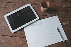 办公桌上放着平板电脑的办公场所。桌子上有一个写字板和一张白纸和一支笔。用于设计展示或作品集。