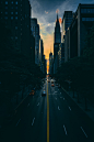 low light photography of vehicle crossing road between high-rise buildings