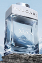 This may contain: a bottle of bvlgari man is sitting on top of a rock with mountains in the background