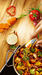 This may contain: a person pouring seasoning into a pot full of vegetables on top of a wooden table
