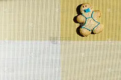 一个戴着饼干面具的男人形象，背景是黄白色的。概念蒙面人的甜品小雕像。