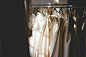 White and beige dresses on hangers in a store