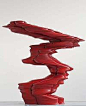 A photograph of an abstract sculpture in red wood.