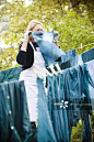 Woman hanging out hand-died blue textiles to dry on washing lines in garden