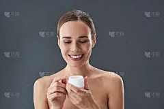 迷人的年轻女子使灿烂的微笑，手里拿着奶油