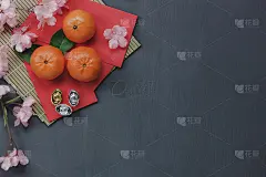 鸟瞰图装饰中国和农历新年的概念背景。将物品和橙子混合放在经典的灰色家庭办公桌上。其他语言意味着富有或