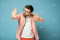男人用手势示意停止，掌心向前，严肃地看着镜头来安慰别人。