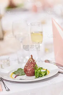 洒上果仁的烤梨摆在喜庆的餐桌上。_5202384605