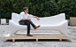 A white concrete outdoor couch made using 3D printing techniques.