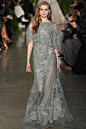 Elie Saab Spring 2015 Couture。艾莉·萨博2015春夏巴黎高级定制时装周在一片片绿色植被花丛中拉开帷幕。本季，以“忧伤的挽歌”向家乡贝鲁特致敬，Elie Saab以“花”为主题，重笔墨于轻盈的流苏与立体花朵装饰之上，结合他对美的深刻理解，用亮片刺绣点缀于薄纱中，轻绢曼纱、珠罗蕾丝，宛若花仙精灵，美得令人窒息。