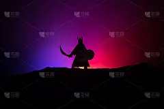 战士用剑勾勒出天空的轮廓。手持剑的中世纪骑士。有选择性的重点