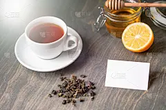 木桌上放着柠檬蜂蜜茶，名片是空白的。