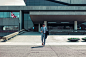 A man in a formal suit checking his smartphone while walking out of an office building