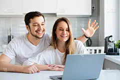 在网上与亲友见面。一对夫妇在笔记本电脑显示器前挥手