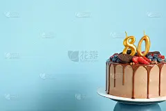 巧克力生日蛋糕，浆果，饼干和80号金色蜡烛蓝色背景墙，复制空间