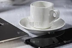 桌子上放着一杯咖啡，手机和笔记本电脑