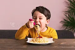 Child is eating spaghetti.Child is eating spaghetti. He is very happy.