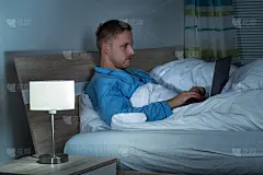 男人在床上用笔记本电脑