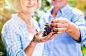 Senior couple in blue shirts holding bunch of grapes