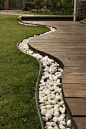 Use rocks to separate the grass from the deck, then bury rope lights in the rocks for lighting. Awesome for front yard