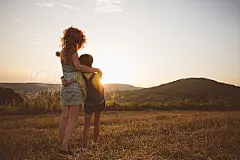 Loving hug of mother and daughter in wheat field