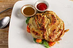 烤鸡胸脯牛排，配黑椒肉汁、什锦蔬菜、蕃茄酱和炸薯条，以木作背景