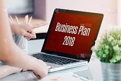商务人士在笔记本电脑屏幕前开会，在办公室桌上写着2018年商业计划，数字营销概念。