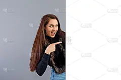 情绪化的年轻女子显示空白招牌与拷贝空间，孤立在灰色