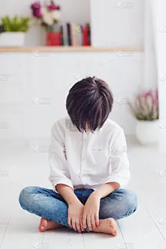 小男孩低下头, 赤脚坐在地板上, 动漫人物
