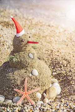 在假日用沙子而不是雪堆雪人。概念热带度假胜地可以用于新年和圣诞贺卡