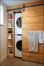 Une porte de grange rustique coulissante en bois pour cacher la buanderie  http://www.homelisty.com/integrer-lave-linge-deco/