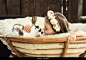 Beautiful little girl in a wreath of flowers kisses a cute fluffy white Easter bunny. Stock Photo