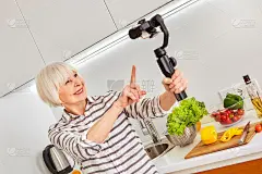 现代自拍视频记录手机相机。新技术在线项目。室内家庭爱好美食博客博主。社交活跃的老年妇女追随者广告制造