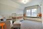 Example of a large classic gender-neutral carpeted nursery design in Minneapolis with gray walls