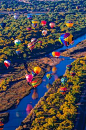 Hot air balloons flying low over the Rio Grande River just after sunrise, Albuquerque International Balloon Fiesta, Albuquerque, New Mexico ...