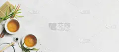 亚洲茶的概念，两杯白茶，茶壶，茶具，筷子，竹垫，周围都是白底干绿茶，上面有文字空间。 煮茶和喝茶.