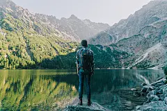 Man walking   near the lake in Tatra  mountainsYoung Caucasian man walking  near Morksie Oko lake in mountains in Poland
