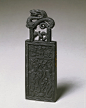 清嘉庆程丽仲压胜钱墨:

通长9.35cm，宽3.3cm，厚0.6cm
墨主体为长方形，上卧圆雕盘龙。正、背两面皆起边框。正面压印阳起的龙、虎、螭、龟，托起一趺坐的仙人，仙人两侧各立一持花童子。背面布满乳钉纹，并仿铜钱锈蚀剥落之状貌。左侧署阴文填金楷书“嘉庆七年程丽仲造”款，右侧面为阴文填金楷书“压胜钱”之墨名。此墨造型仿金属压胜钱形状。