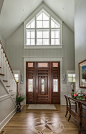 Beach style medium tone wood floor and brown floor entryway photo in Baltimore with gray walls and a dark wood front door