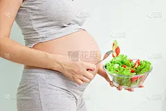 健康的营养和怀孕。孕妇的肚子和蔬菜沙拉。孕期营养。素食主义和怀孕。孕期维生素，孕期饮食