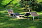 设计一个波浪线形状的长凳。金属镀锌框架上的木质镶板。这张长椅在城市公园里对年轻人来说是不常见的，坐着