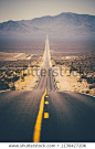 Classic panorama view of an endless straight road running through the barren scenery of the American Southwest with extreme heat haze on a beautiful sunny day with blue sky in summer