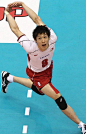 This may contain: a man in red shorts and white shirt playing volleyball