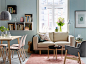 A cosy area in a small open-plan living room / dining area featuring the NORSBORG 2-seat sofa in Edum beige and VEDBO armchair in Gunnared dark grey beside a YPPERLIG coffee table in dark grey against a backdrop of blue.