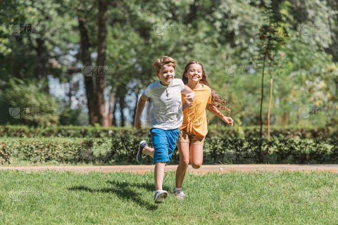 美丽快乐的孩子们在公园草地上奔跑